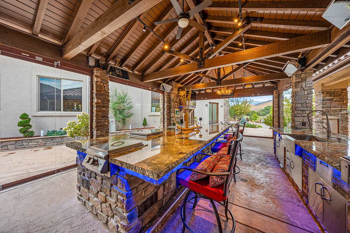 frameless movable glass doors create a luxury outdoor kitchen year-round