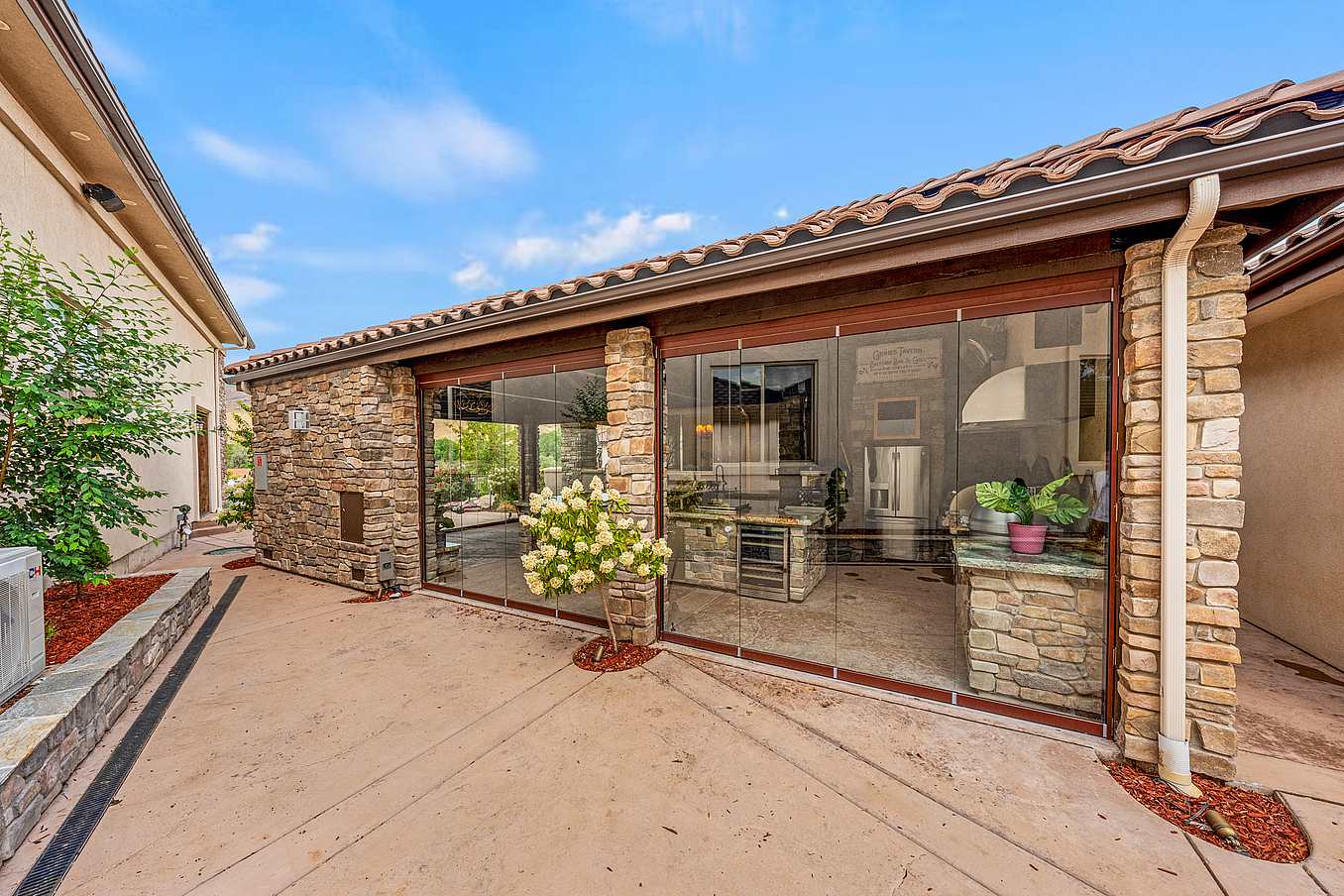 all-glass movable glass doors protect outdoor kitchen