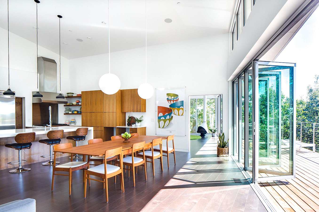 folding glass wall partially open in dining room with hillside view