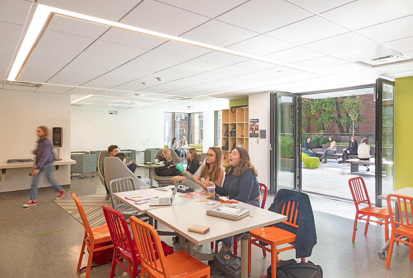 student commons with fresh air and daylight through folding door in modern school design