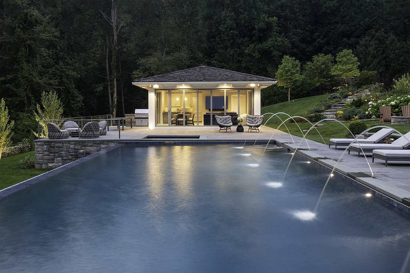 pool house with folding glass walls in nightime