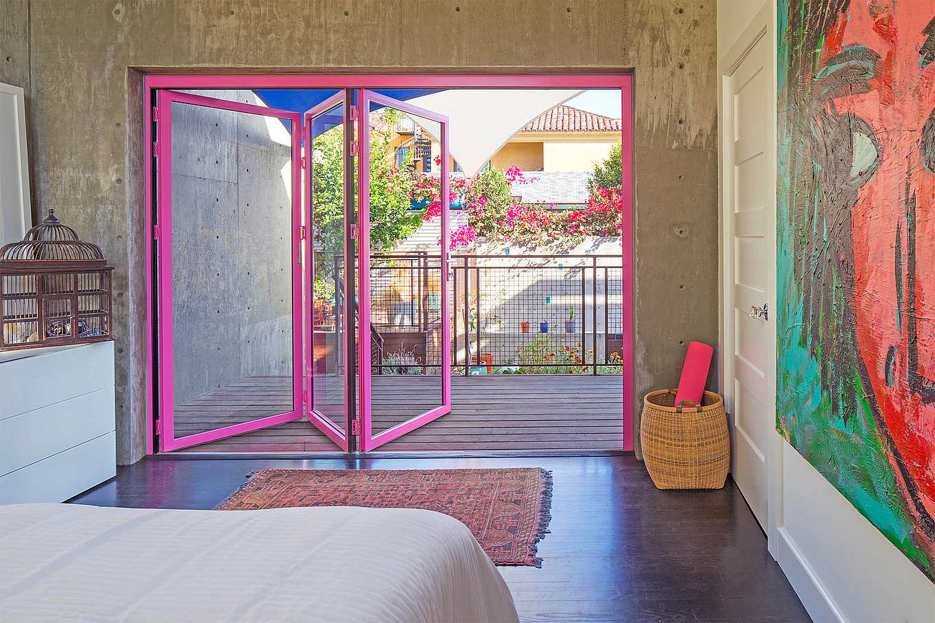 NanaWall folding glass wall in bold pink finish, showcasing custom color options, sleek design, and all-climate thermal break performance