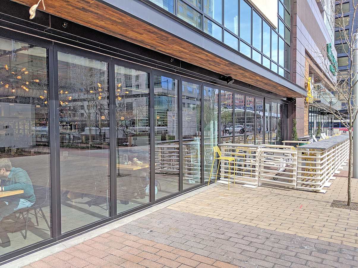 Whole Foods lower level moving glass wall systems separates eating area from sidewalk