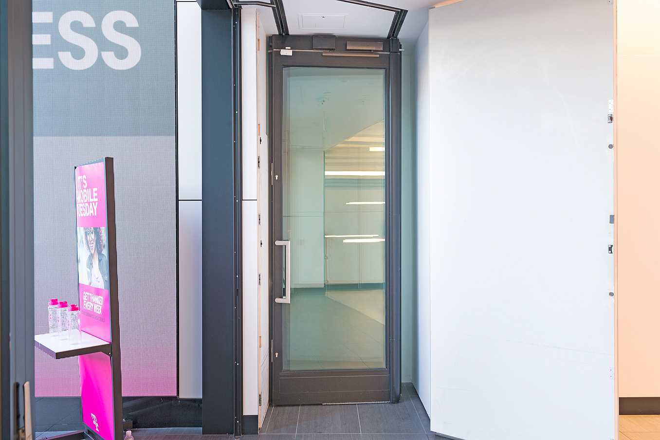 NanaWall commercial glass door system that disappears in storage closet at T-Mobile