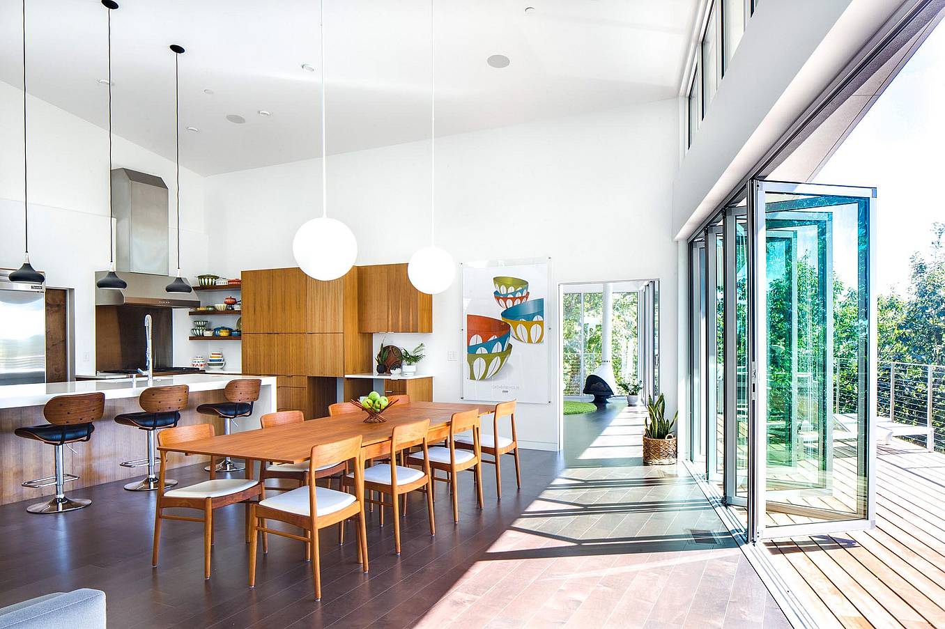 folding glass wall partially open in dining room with hillside view