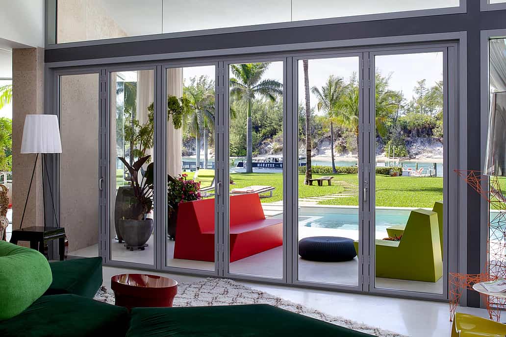NanaWall SL73 impact-rated folding glass wall system at a Florida coastal home, designed to meet Florida Product Approval and HVHZ requirements