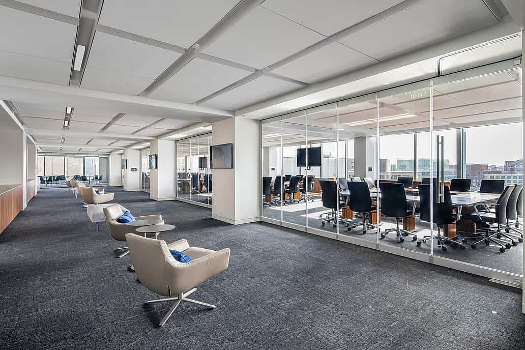 Modern office with a conference room separated by closed sliding glass walls featuring a single-track sliding system.