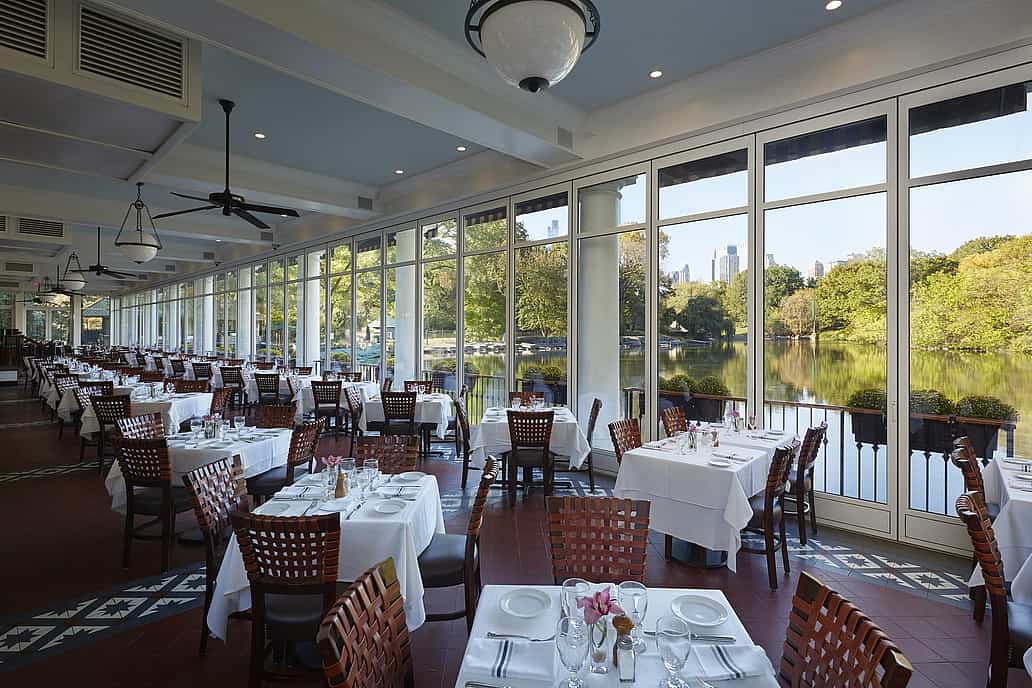 The Loeb Boathouse Central Park, New York, NY | Restaurant with floor-to-ceiling sliding glass doors overlooking a scenic lake. 