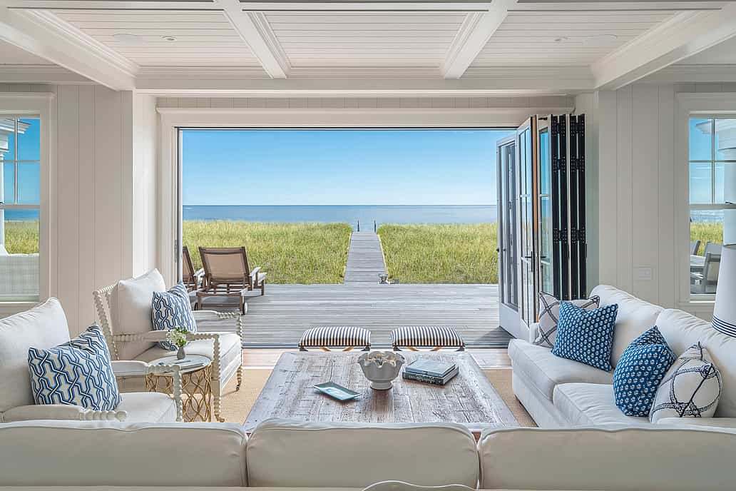 NanaWall wood-clad folding glass wall system at a Scarborough residence, opening the interior living space to an ocean view patio