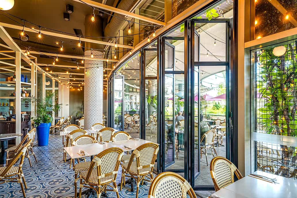 NanaWall glass wall system in a restaurant setting in Quebec, showcasing durable performance for daily commercial use and code-compliant installation