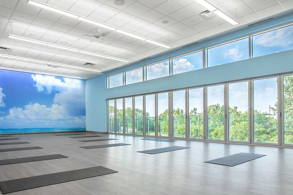Movati athetlectic facility yoga room with closed folding glass wall