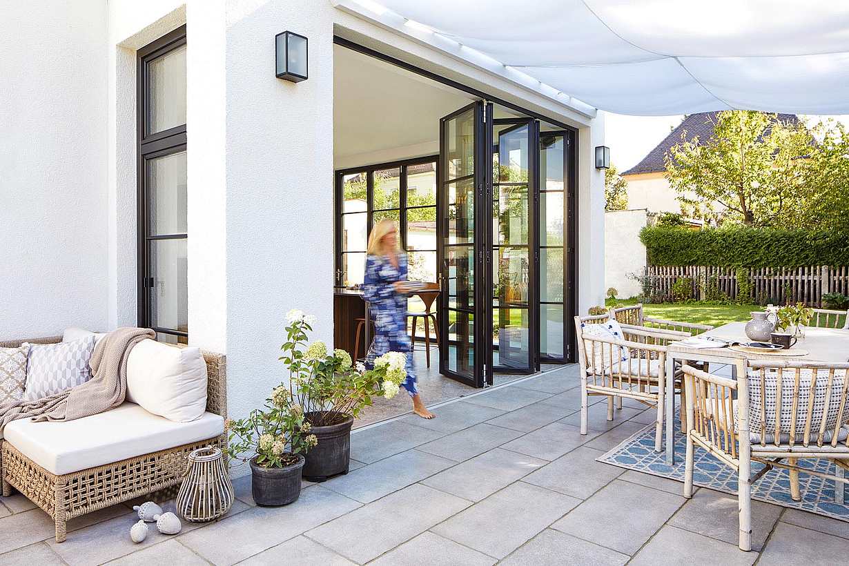 woman walking throught patio door alternatives with folding patio doors