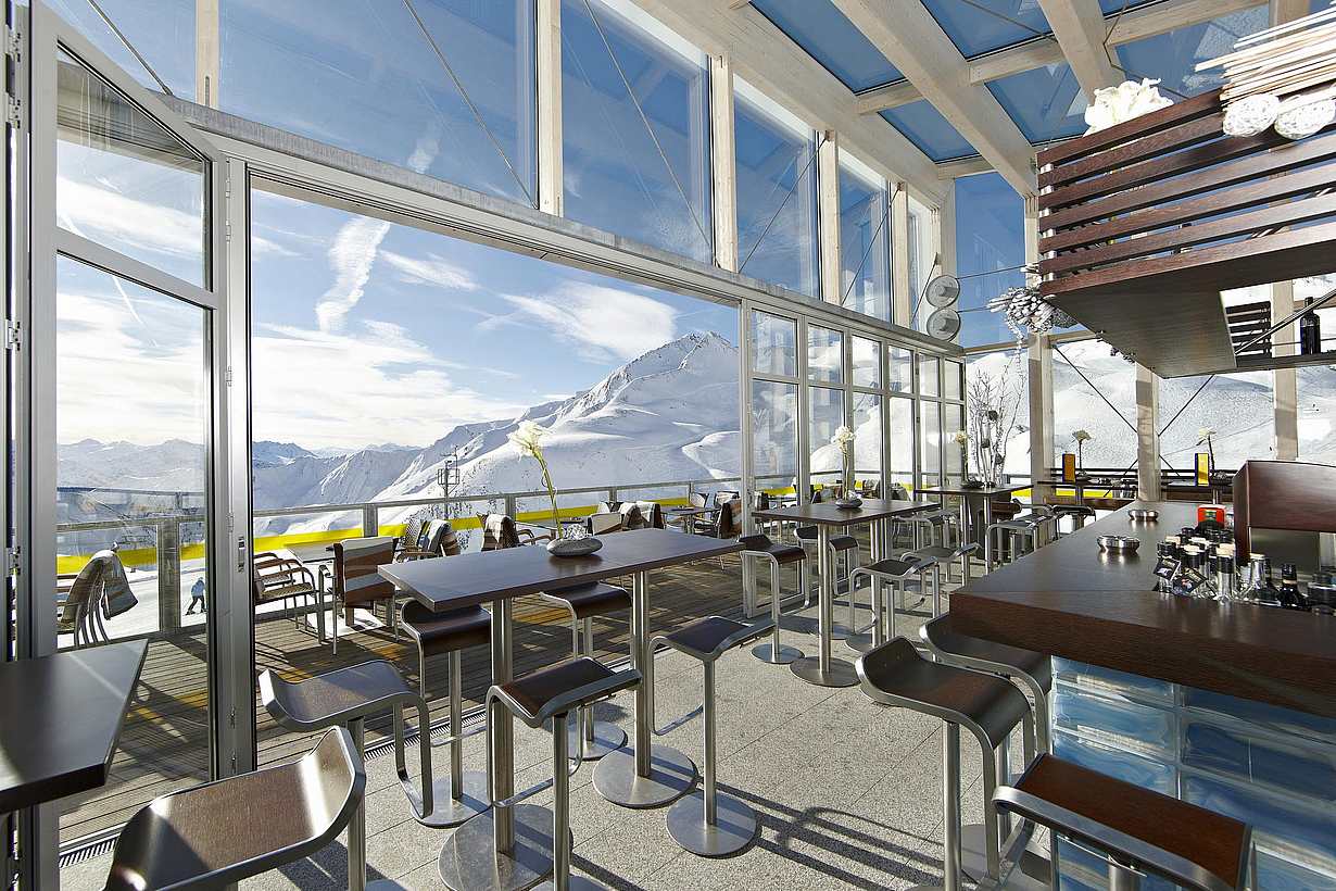 NanaWall SL70 folding glass wall system at a high-traffic panoramic bar in Serfaus, Austria, showcasing long-term mechanical reliability and performance in commercial hospitality settings