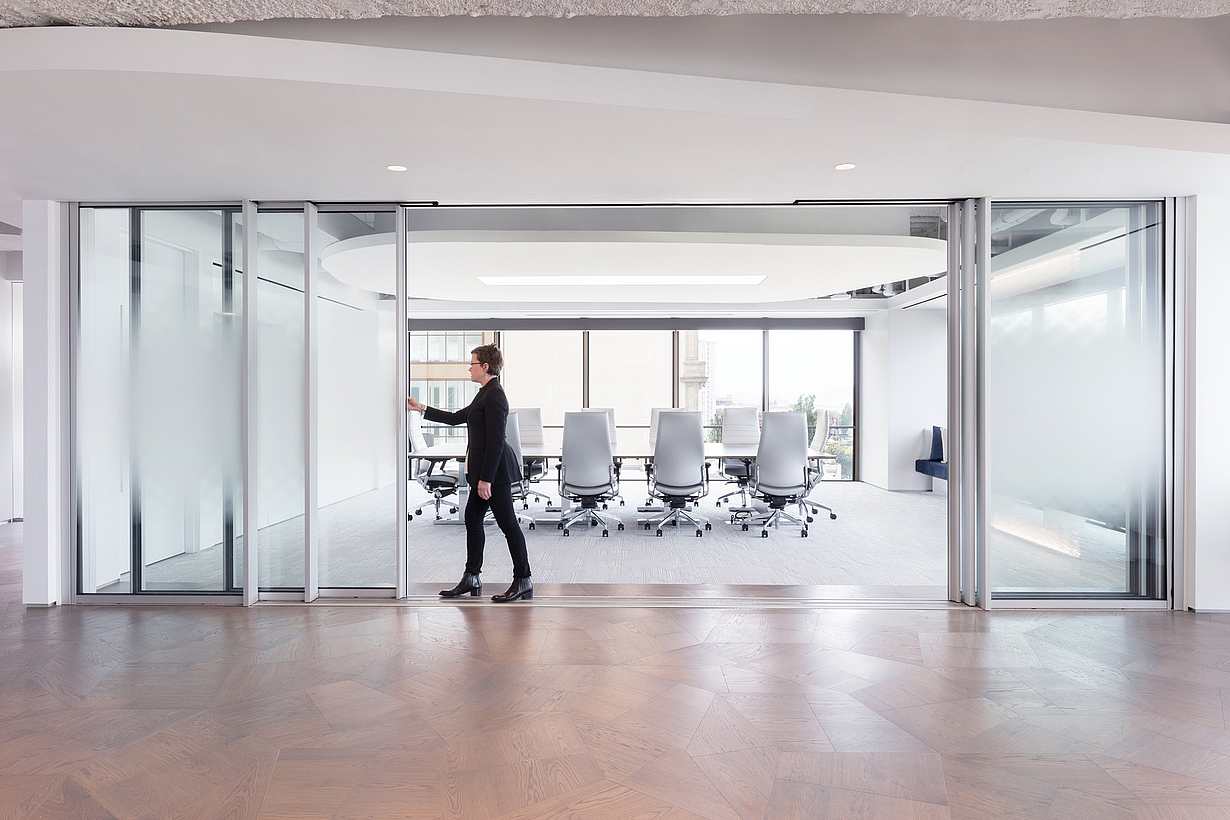 Corporate office interior with Cero minimal sliding glass walls separating workspaces and circulation areas.