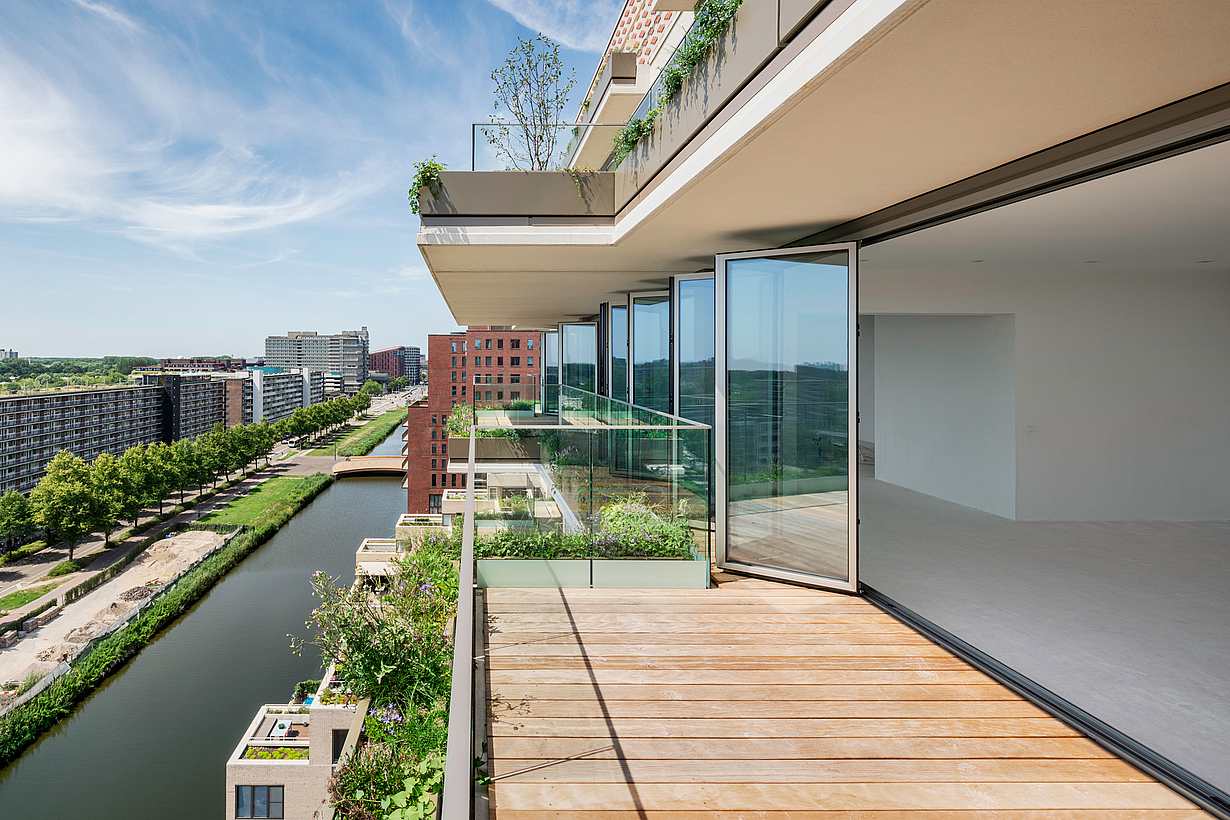 Modern apartment with aluminum accordion glass doors and large balcony overlooking the canal.