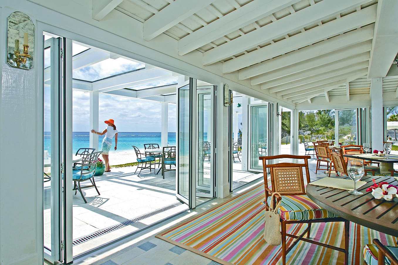 Impact-rated NanaWall folding glass wall system in a coastal Bermuda residence, providing large-panel openings with tested structural and weather performance