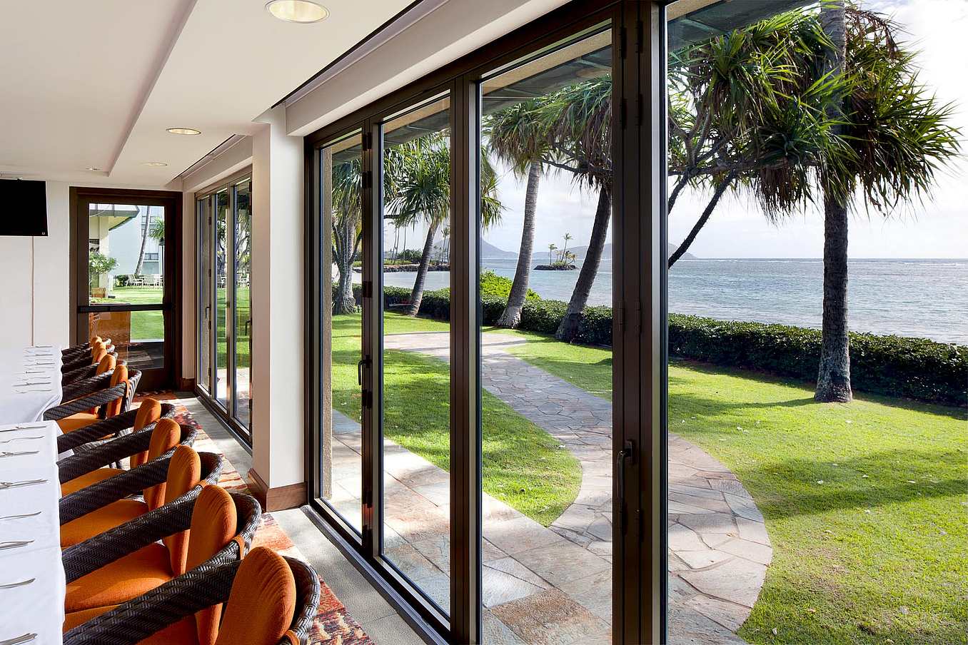 Impact-rated NanaWall SL73 folding glass wall system at Waialae Country Club in Honolulu, HI, designed for HVHZ and coastal wind loads