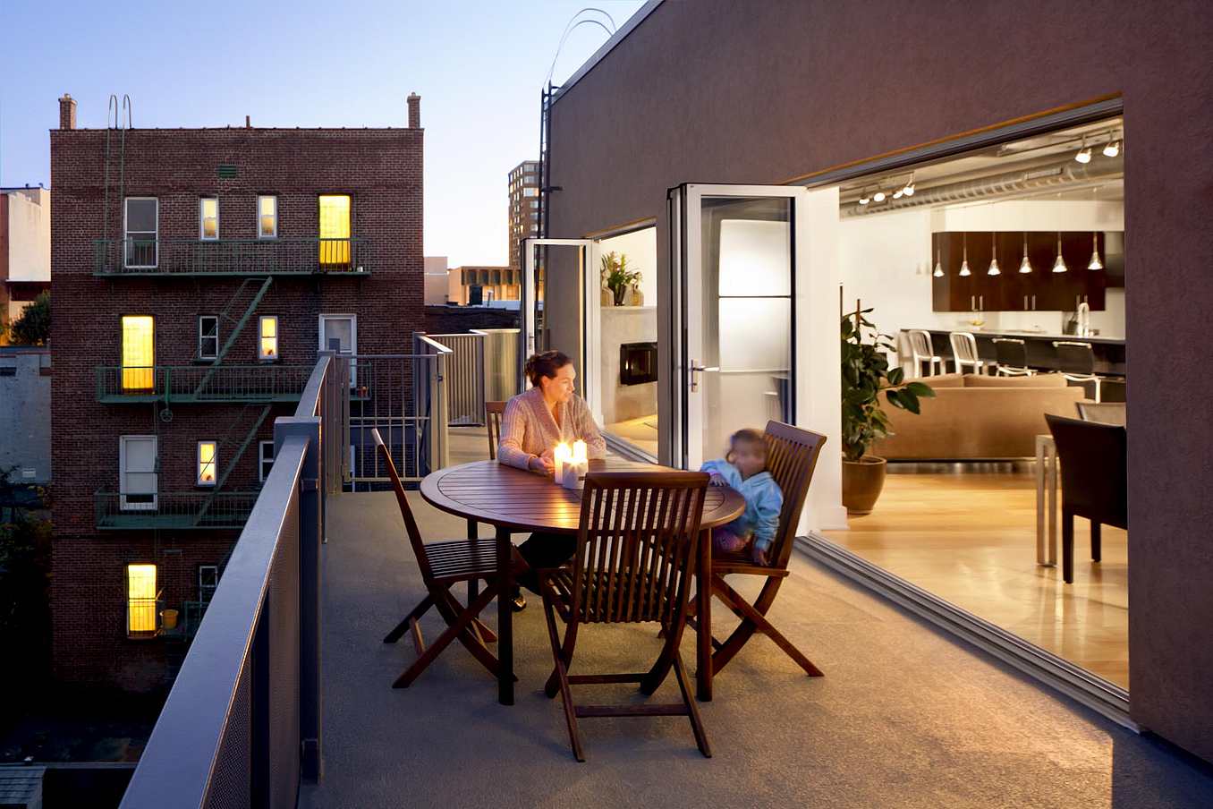 Folding exterior doors open to a balcony, creating a multifunctional outdoor living room in a modern New Jersey home