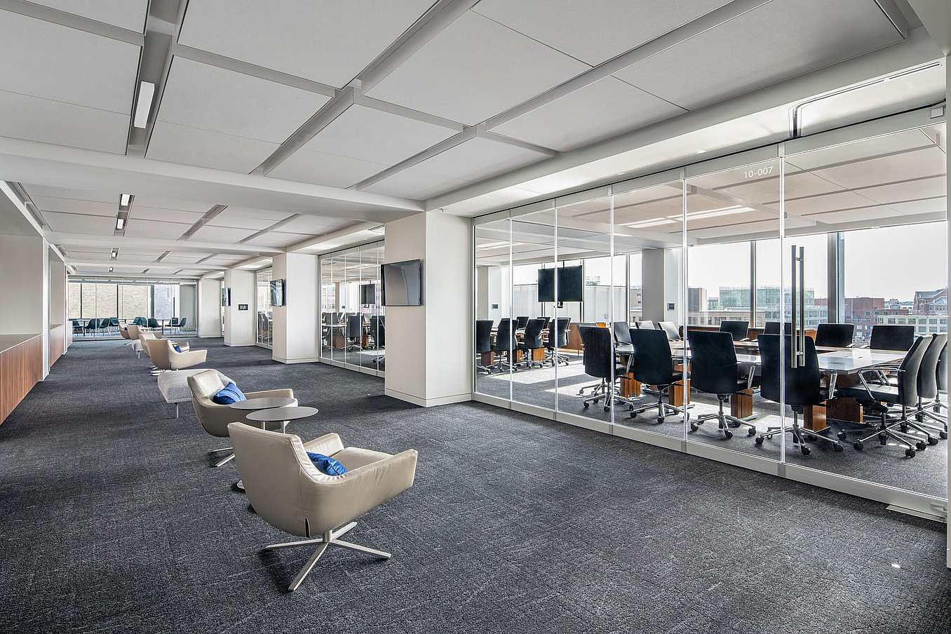 Modern office with a conference room separated by closed sliding glass walls featuring a single-track sliding system.