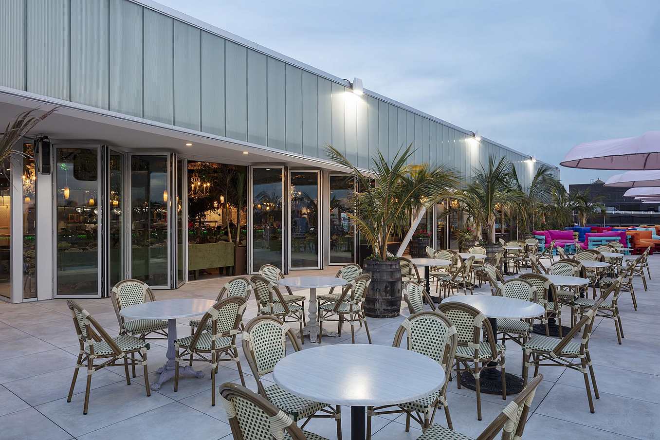 NanaWall folding glass wall system in a hospitality setting, creating expansive indoor-outdoor openings for large gatherings while supporting structural performance and daily use