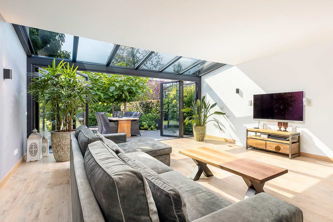Accordion glass patio doors at Heemstede Residence fully open to connect the bright interior with a private, green outdoor space