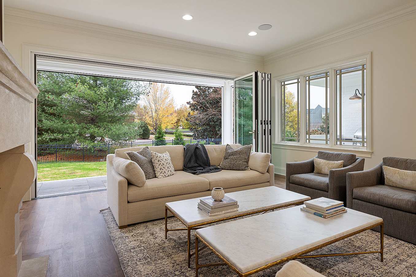 A living room with folding glass walls and a fireplace