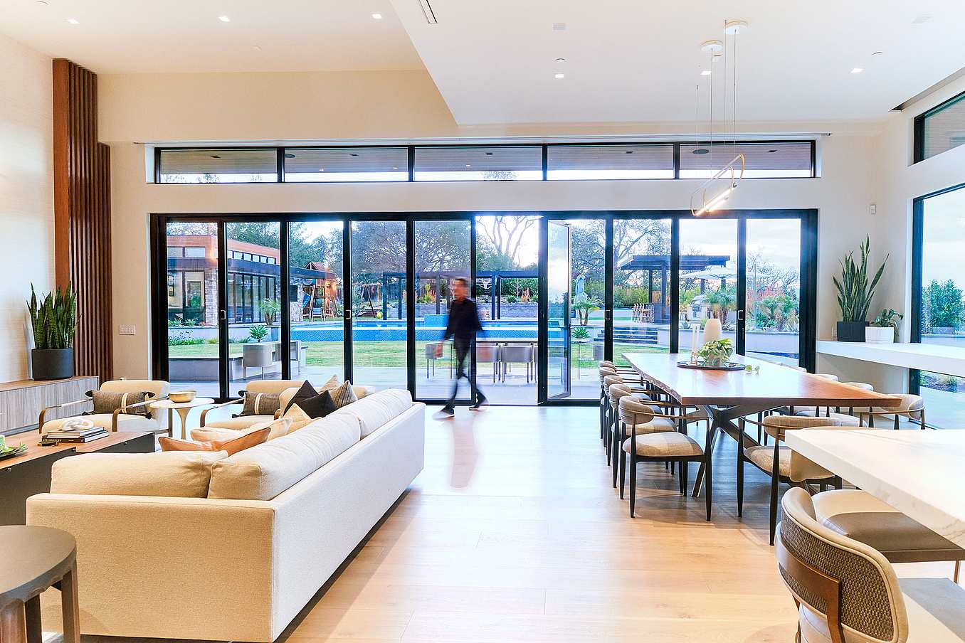 A modern living room featuring aluminum framed bifold glass walls