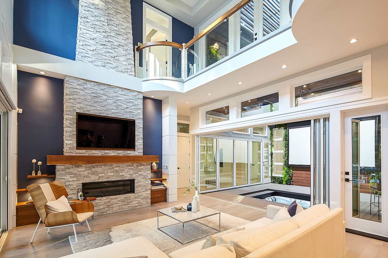 Accordion glass patio doors transform this modern living space, opening indoor area to adjacent patio with sleek style