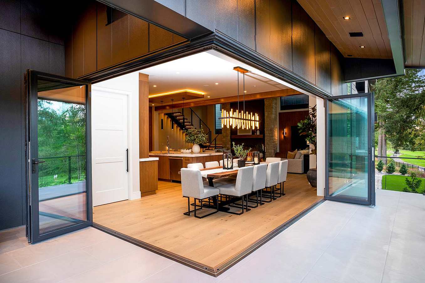 NanaWall NW Aluminum 640 folding glass wall with an open corner configuration, fully opening a dining room to the outdoor living area