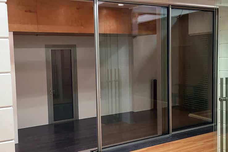 Modern interior with sliding glass doors, dark flooring, and a closed door, offering seamless style and automation potential.