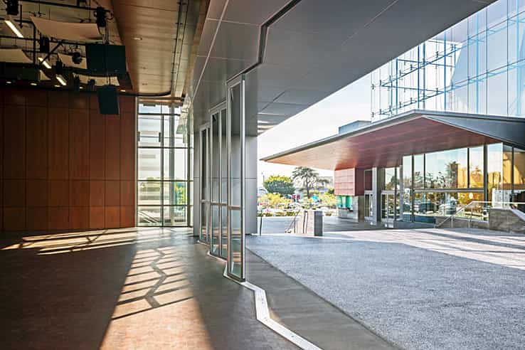 Modern building interior with large sliding glass doors featuring a zig-zag sill design, seamlessly opening to an outdoor area.