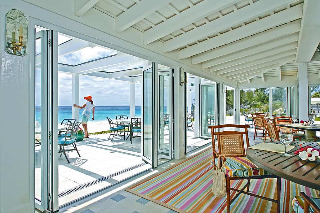 Impact-rated NanaWall folding glass wall system in a coastal Bermuda residence, providing large-panel openings with tested structural and weather performance