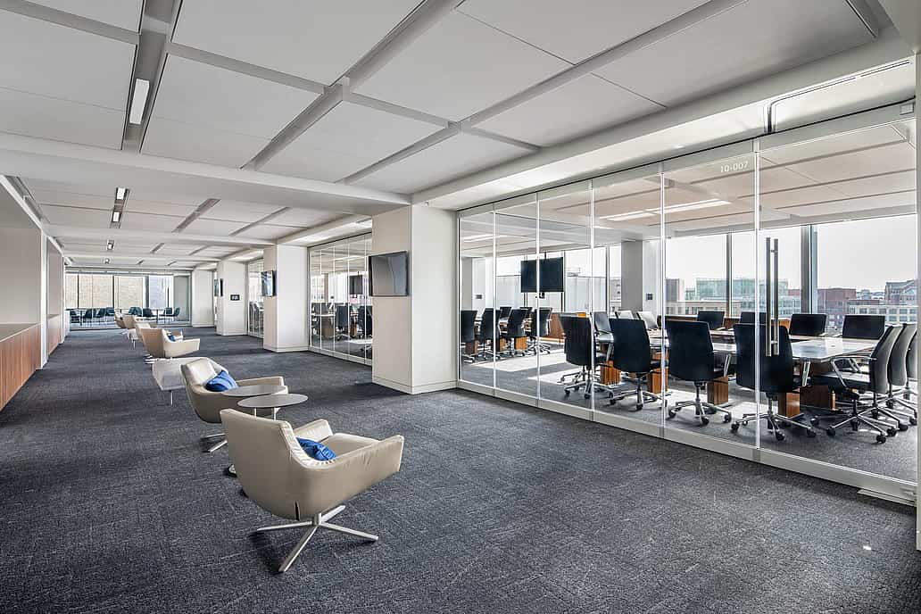 Modern office with a conference room separated by closed sliding glass walls featuring a single-track sliding system.