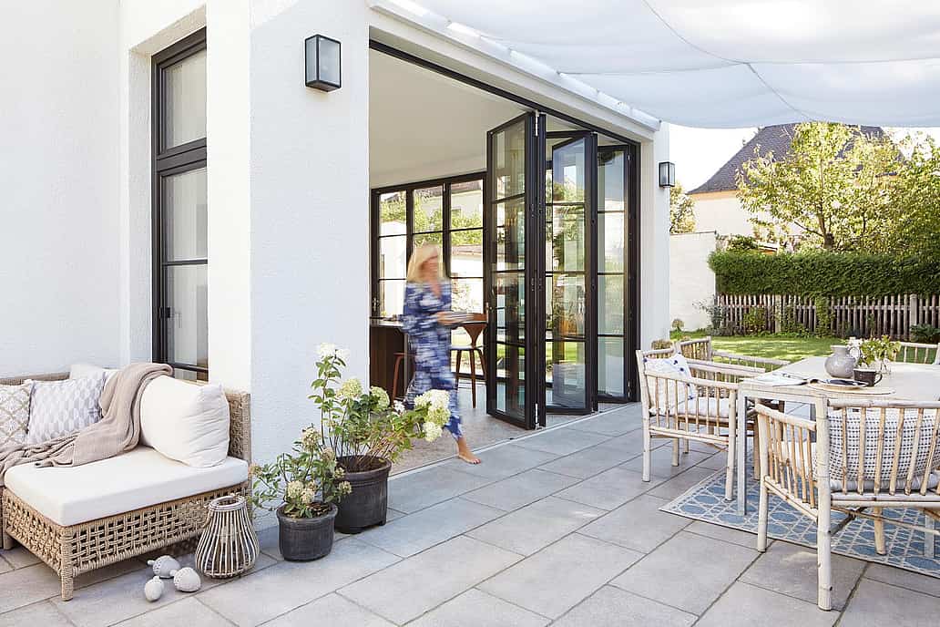 Folding glass patio doors with minimal frames seamlessly connect indoor and outdoor spaces, maximizing natural light and energy efficiency