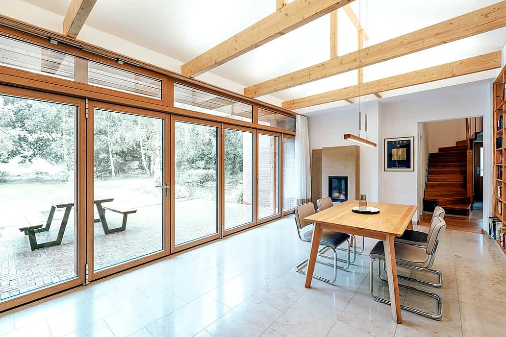 NW Wood 540 folding glass wall at Bramsche farmhouse with slim-profile wood frames, custom-built for real performance and all-climate use