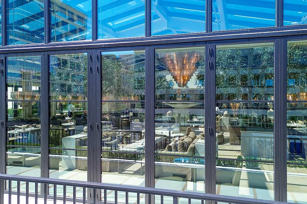 Restoration Hardware rooftop restaurant in Raleigh NC showcasing NanaWall SL70 folding glass doors closed, enclosing elegant dining space with panoramic views