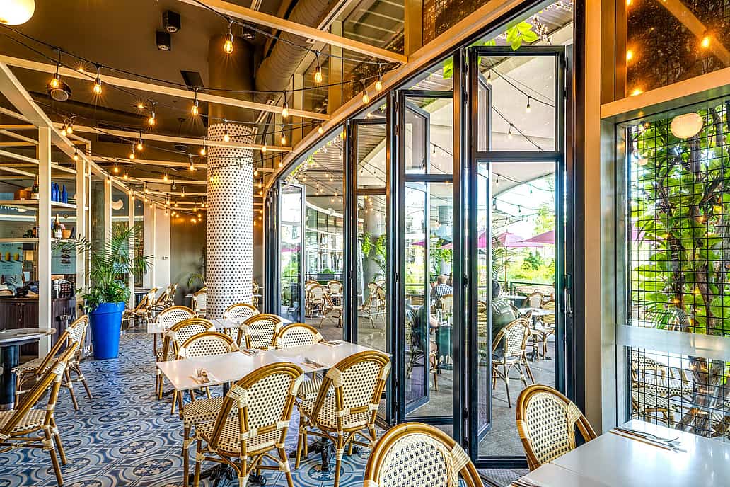 NanaWall glass wall system in a restaurant setting in Quebec, showcasing durable performance for daily commercial use and code-compliant installation