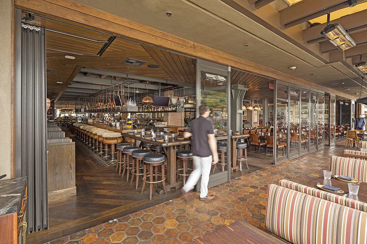 opening the commercial stacking glass doors at a restaurant 