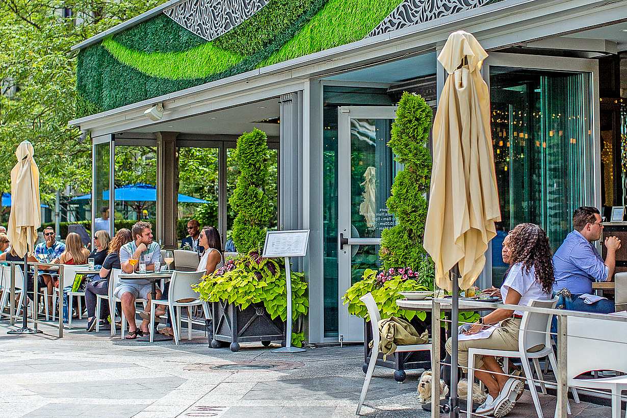 indoor outdoor restaurant with exterior stacking glass doors attracts customers