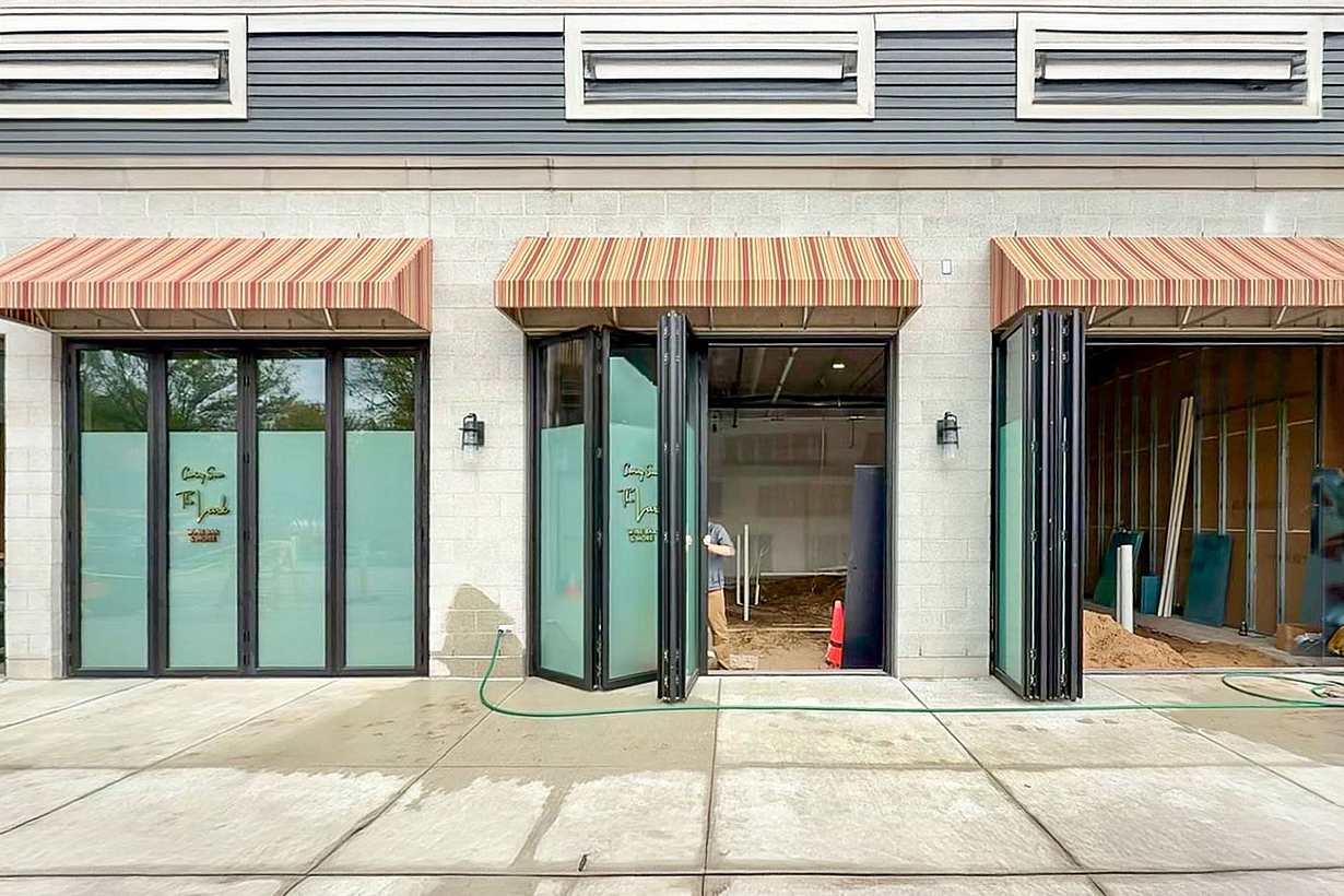 A building exterior features bifold glass doors, enhancing the hospitality design.