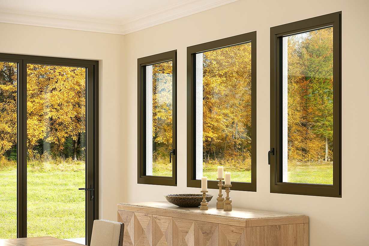 Three fixed windows in a beige dining room reveal an autumn landscape with trees and grass. 