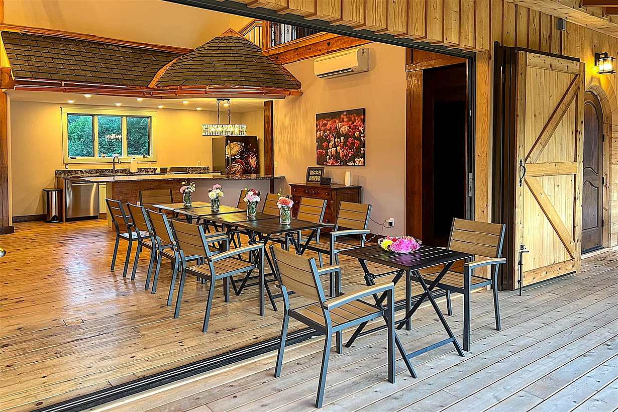 Barn conversion kitchen and dining area connected to an outdoor patio through wide bifolding patio doors