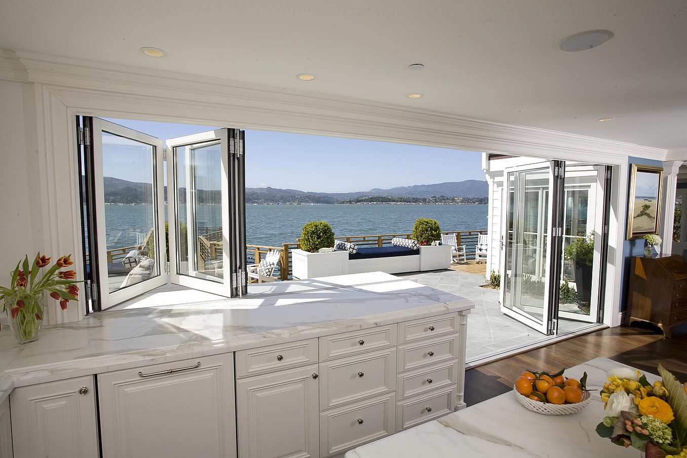 Folding window and door combination in Belvedere, CA kitchen creates seamless indoor-outdoor flow for cooking and dining