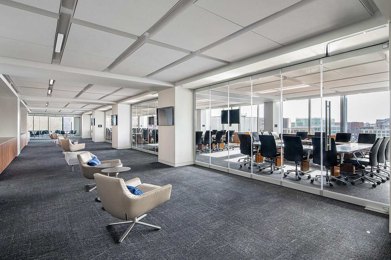Modern office with a conference room separated by closed sliding glass walls featuring a single-track sliding system.