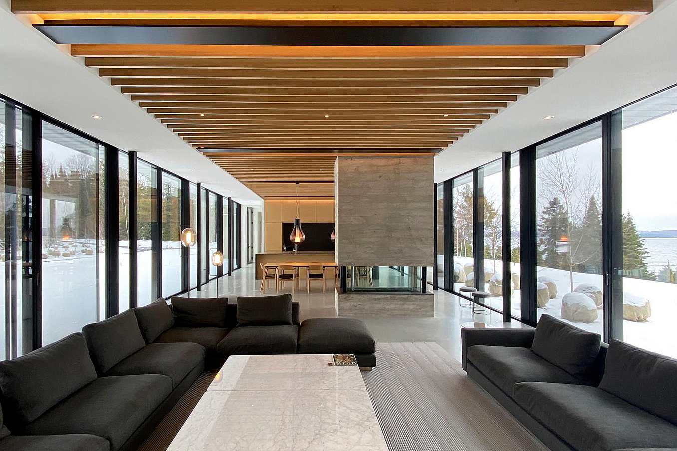 Interior living space with tall thermally broken, NFRC-certified NanaWall glass walls overlooking a snowy landscape
