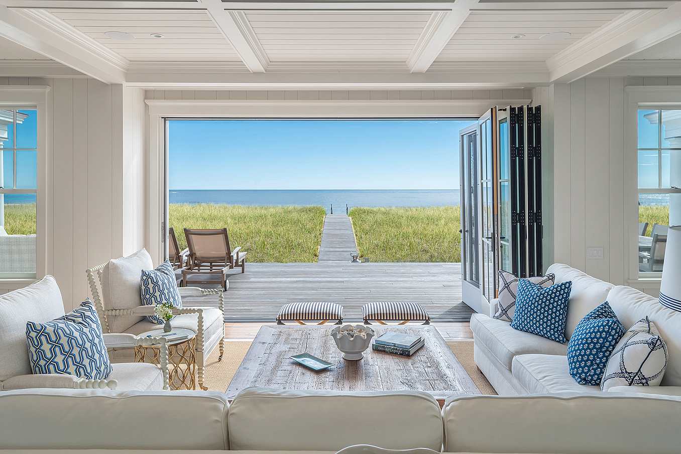 NanaWall wood-clad folding glass wall system at a Scarborough residence, opening the interior living space to an ocean view patio