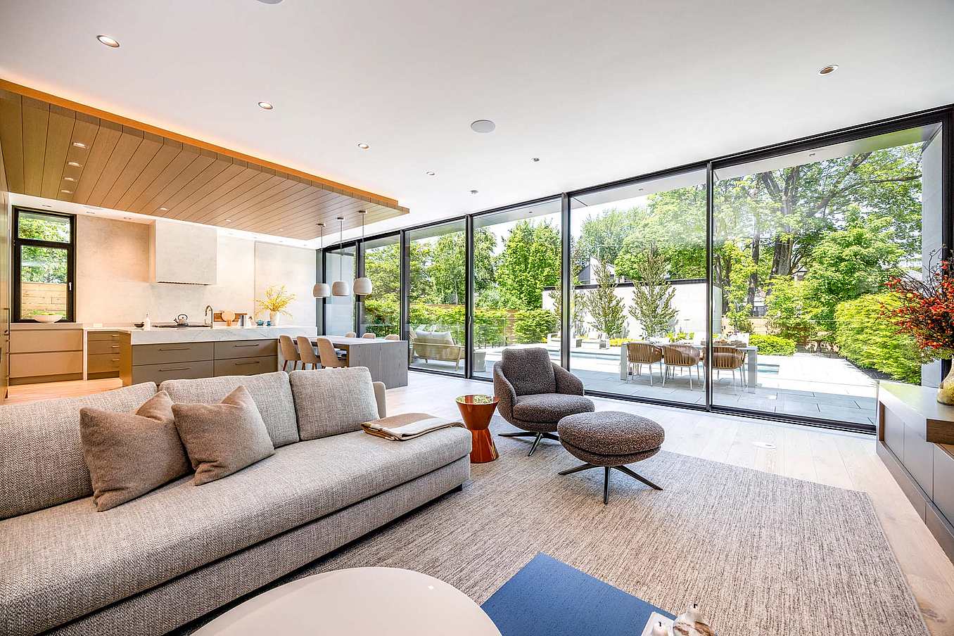 NanaWall Cero sliding glass doors at a Teddington Park residence, opening a modern living room and kitchen to an outdoor patio