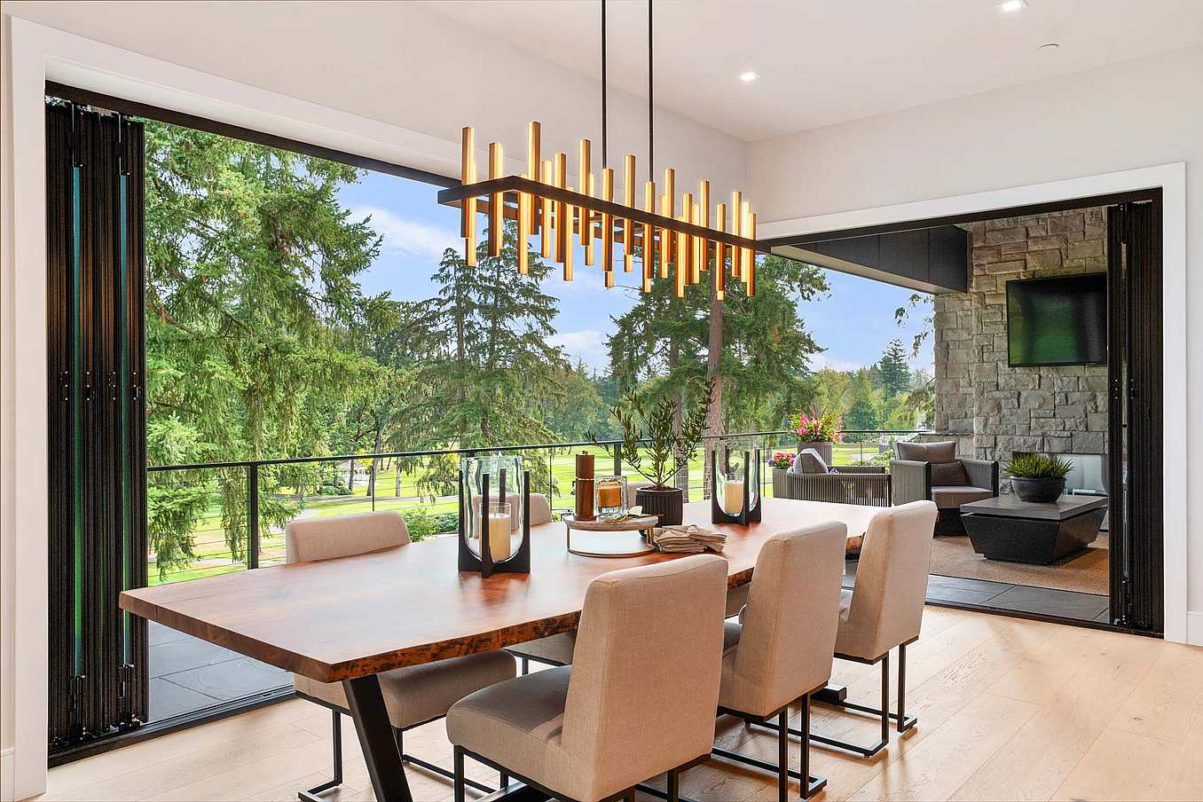 Thermally broken NanaWall NW Aluminum 640 folding glass wall system fully opened in a dining room, creating a wide indoor–outdoor opening with unobstructed views