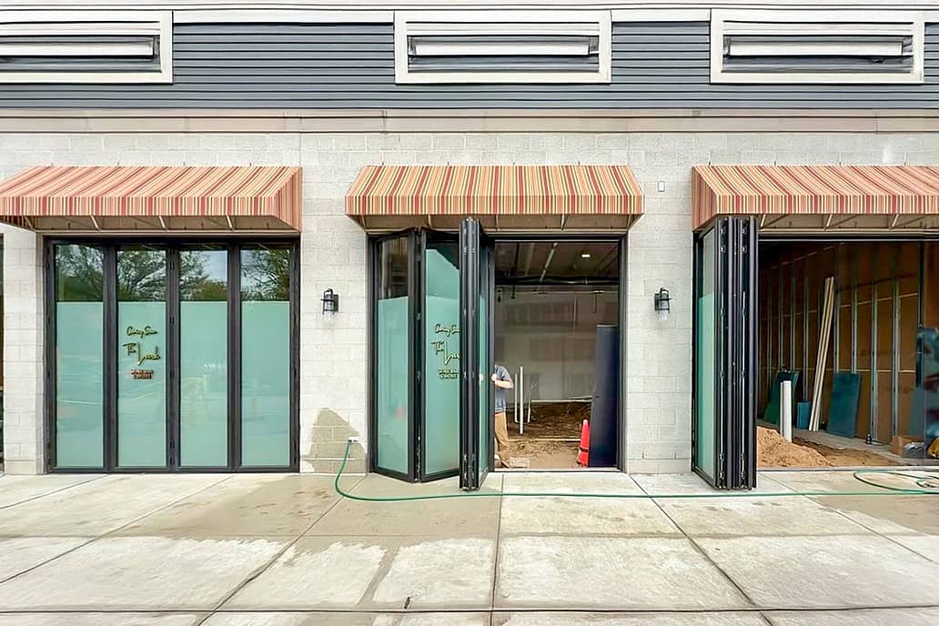 A building exterior features bifold glass doors, enhancing the hospitality design.