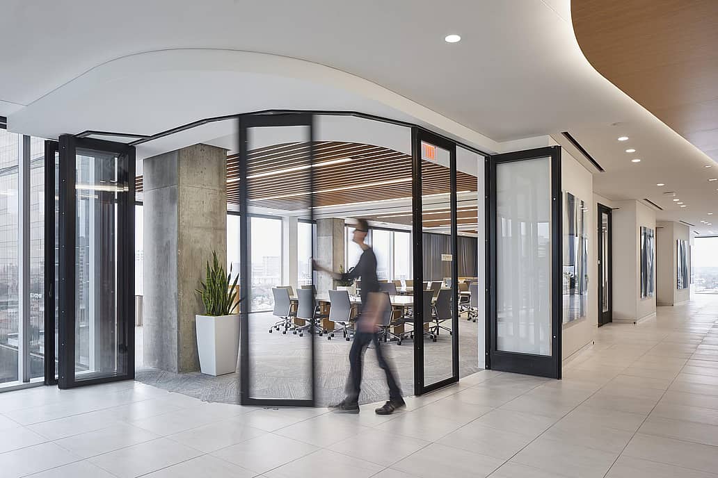 Commercial office space segmented curved sliding glass walls